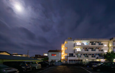 Moon light over apartment building in quiet neighborhood at night