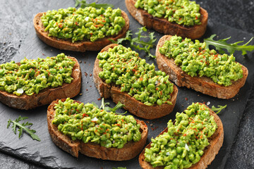 Mashed peas sourdough bread toast with sea salt flakes and chilli served on black slate