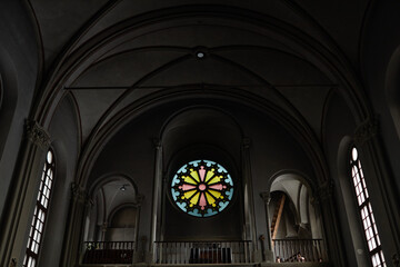 Low angle view of baptist church with dark walls and stained glass inside - Powered by Adobe
