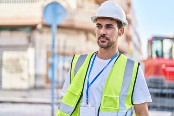 Young hispanic man architect standing with relaxed expression at street