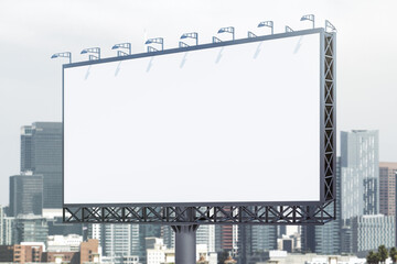 Blank white billboard on city buildings background at daytime, perspective view. Mockup, advertising concept