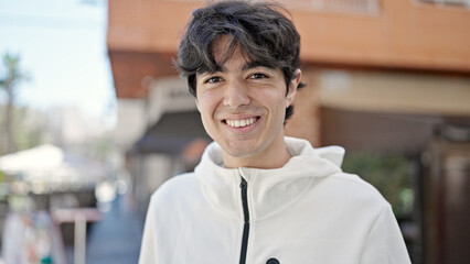 Young hispanic man smiling confident standing at street