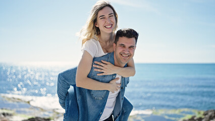 Man and woman couple smiling confident standing on back at seaside
