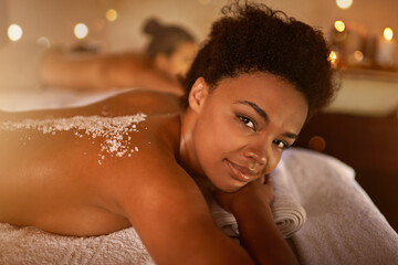 Obraz na płótnie Canvas Salt, spa application and black woman portrait of customer at a hotel with lying for massage. Exfoliate therapy, luxury and relax treatment of a female person back for skincare and wellness