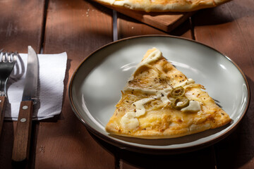 Una porción de pizza pollo catupiry sobre un plato redondo 