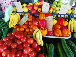Colorful assortment of fresh ripe organic fruits, apples, bananas, tangerines, displayed for sale on farmer market shelves. Agriculture. Agribusiness. Food and drink industry and consumerism. Veganism