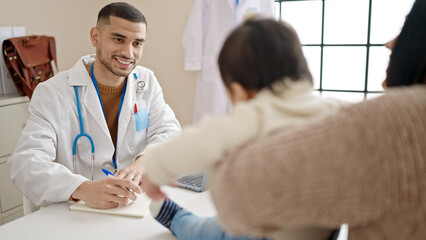 Obraz premium Couple and son having medical consultation writing on notebook at clinic