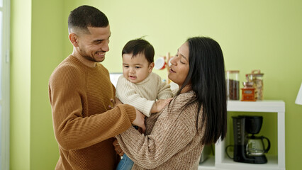 Couple and son hugging each other standing at home