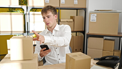 Young caucasian man ecommerce business worker make photo to packages at office