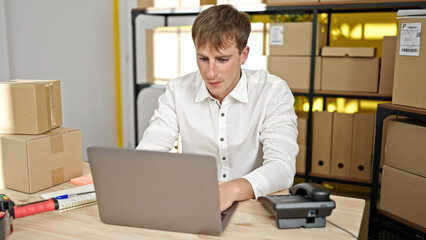 Young caucasian man ecommerce business worker using laptop sitting on table at office