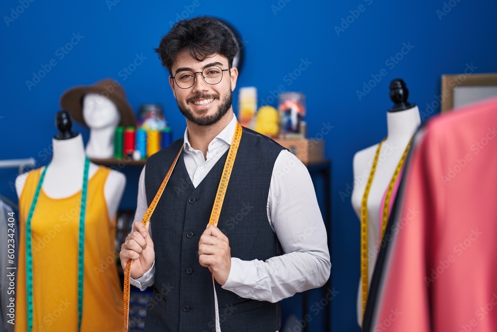 Sticker young hispanic man tailor smiling confident standing at sewing studio