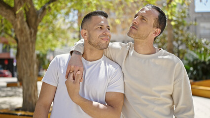 Obraz premium Two men couple hugging each other at park