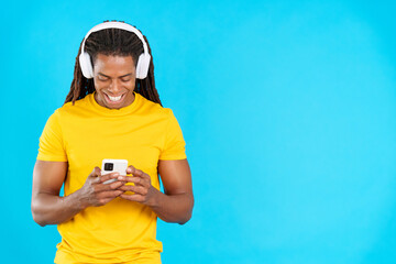 Latin man listening to music with headphones and a mobile
