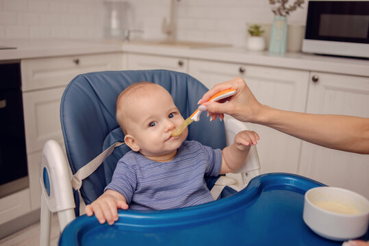 A Beautiful Baby Eating Mashed Potatoes. Mom Feeds Baby.