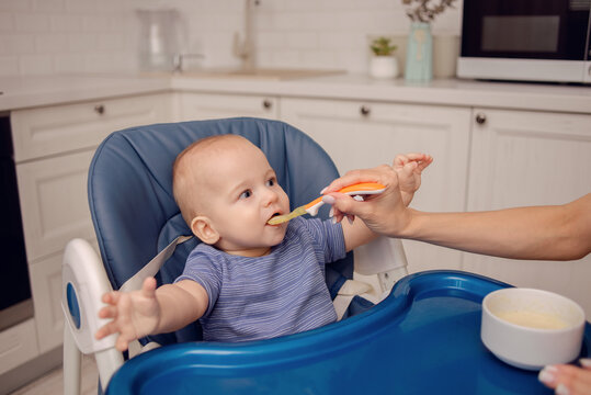 A Beautiful Baby Eating Mashed Potatoes. Mom Feeds Baby.