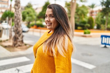 Young beautiful plus size woman smiling confident looking to the side at street