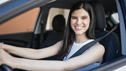 Obraz na płótnie Canvas Young beautiful hispanic woman smiling confident driving car at street