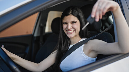 Fototapeta na wymiar Young beautiful hispanic woman smiling confident holding key of new car at street