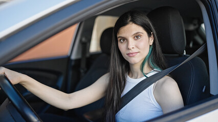 Plakat Young beautiful hispanic woman driving car at street