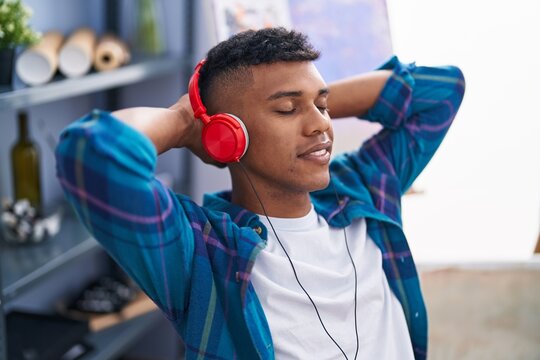 Young latin man artist listening to music relaxed at art studio