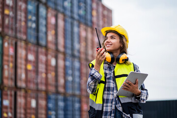 Beautiful female worker working in a safety suit at a port warehouse. Security check in port...