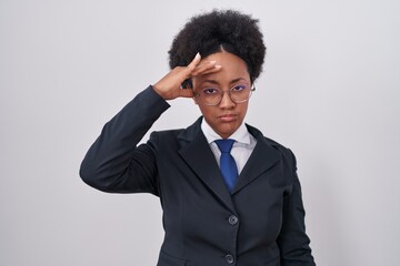 Beautiful african woman with curly hair wearing business jacket and glasses worried and stressed about a problem with hand on forehead, nervous and anxious for crisis