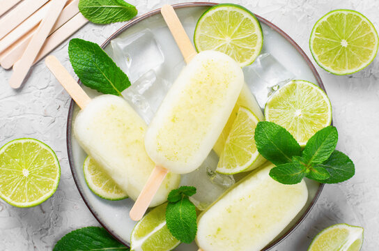 Refreshing Lime Popsicles, Brazilian Lemonade Ice Lolly with Fresh Lime and Mint on Bright Background