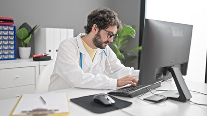 Fototapeta na wymiar Young hispanic man doctor using computer working at clinic