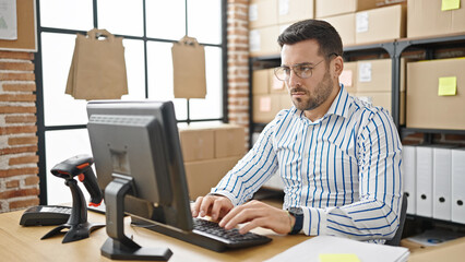 Young hispanic man ecommerce business worker using computer at office