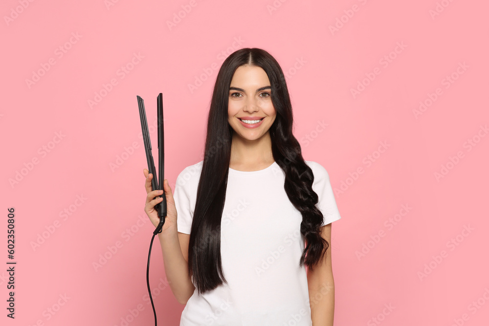 Sticker Beautiful happy woman with hair iron on pink background