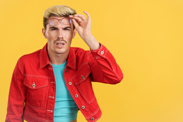 Gay man taking off the glasses to see far away