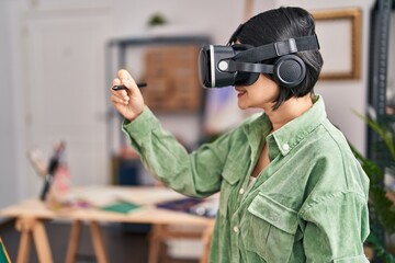 Young chinese woman artist using vr glasses drawing at art studio