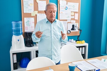 Middle age grey-haired man business worker speaking at office