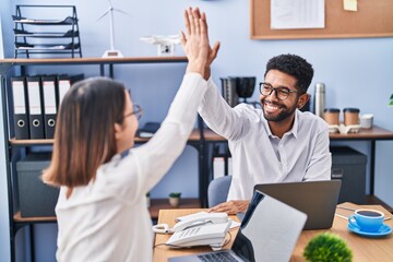 Man and woman business workers high five with hands raised up at office