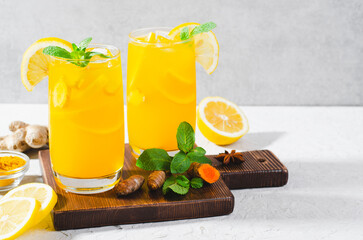 Ginger and Turmeric Lemonade, Healthy Refreshing Beverage with Turmeric Root and Spices, Jamu Juice, Immunity Booster Drink on Bright Background