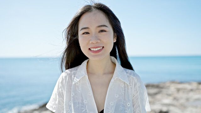 Young chinese woman smiling confident standing at seaside