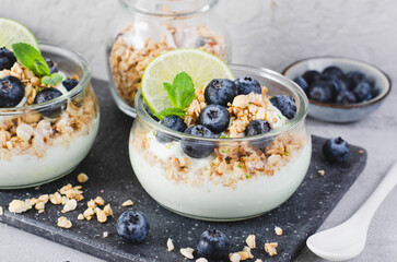 Crunchy Granola with Yogurt, Lime and Blueberries, Dessert Parfait, Healthy Snack or Breakfast on Bright Background