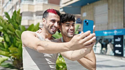 Two men couple smiling confident having video call at park