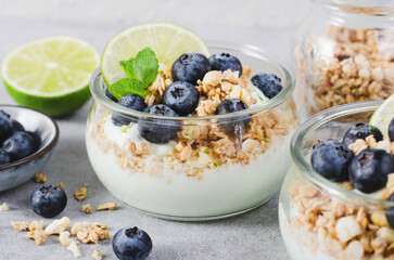 Crunchy Granola with Yogurt, Lime and Blueberries, Dessert Parfait, Healthy Snack or Breakfast on Bright Background