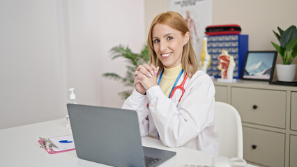 Young blonde woman doctor using laptop working at clinic