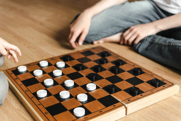 two brothers in white T-shirts are playing checkers. early development. intellectual games. a...