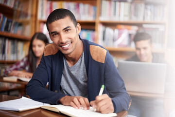Study, writing and library with portrait of man for education, research and classroom quiz. Smile, learning and notebook with male student on university campus for knowledge, scholarship and project