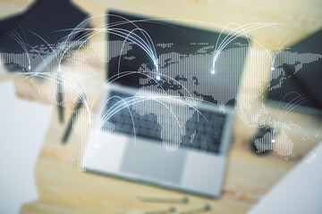 Double exposure of abstract digital world map with connections on laptop background, research and strategy concept