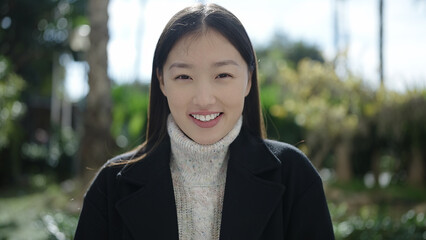 Young chinese woman smiling confident standing at park