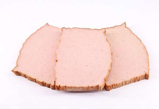 Slices of Leberkase on white background. It is a german speciality consisting of beef, pork and bacon and is made by grinding this ingredients and then baking. 