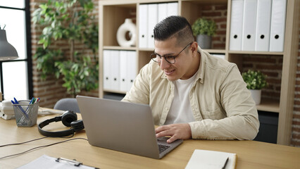Young hispanic man business worker using laptop working at office