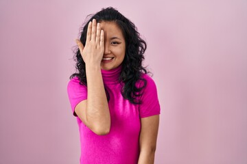 Young asian woman standing over pink background yawning tired covering half face, eye and mouth with hand. face hurts in pain.