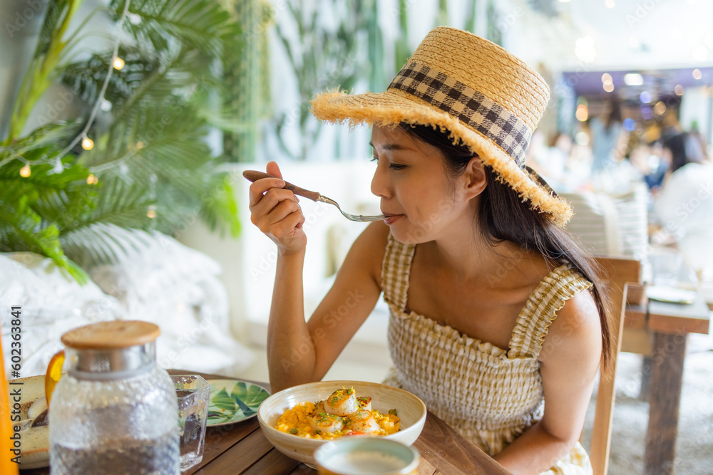 Wall mural Woman enjoy the scallop pasta in restaurant