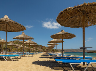 The sandy beach of Vai and empty umbrellas at the beginning of the tourist season on the southern coast of Crete, Greece