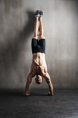 Fitness body, wall and man doing handstand for muscle workout, balance focus or health club...